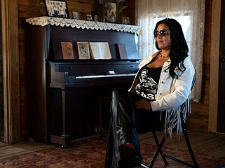 Tina Cossey, sitting at the boyhood home of Johnny Cash in Dyess, has been inspired by all types of music. (Special to The Commercial/Hayden Valentine)